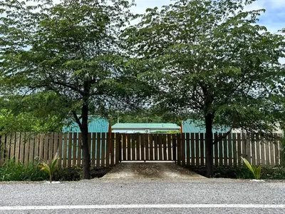 a wooden fence with two trees in front of it at Eco Glamping Verde, Bahia Gigante in Puntarenas