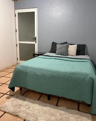 a bedroom with a bed with a green blanket at Apartamento Pequeño descanso San Ramon in San Ramón