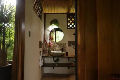 a bathroom with a sink and a mirror at El santuario - Cabin by a River in Fortuna
