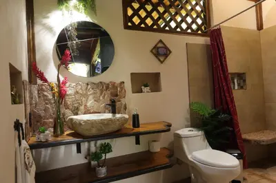 a bathroom with a sink and a toilet at El santuario - Cabin by a River in Fortuna