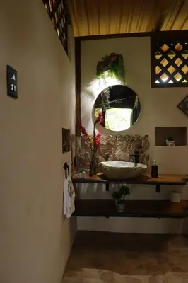 a bathroom with a sink and a mirror at El santuario - Cabin by a River in Fortuna