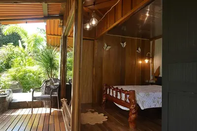 a bedroom with a bed in a wooden room at El santuario - Cabin by a River in Fortuna