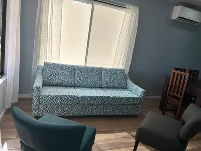a living room with a blue couch and two chairs at Villas Carari in Hatillo