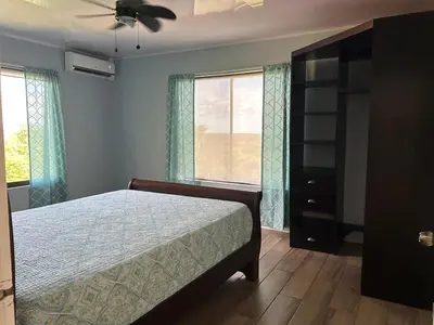 a bedroom with a bed and a large window at Villas Carari in Hatillo