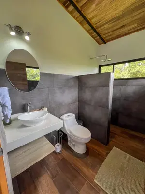 a bathroom with a toilet and a sink and a mirror at Casa Micelio in Monteverde Costa Rica