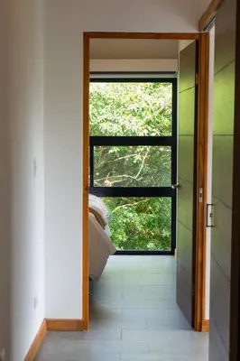 a door leading to a bedroom with a window at Casa Micelio in Monteverde Costa Rica
