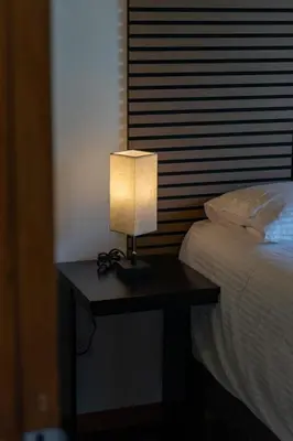 a table with a lamp on it next to a bed at Casa Micelio in Monteverde Costa Rica