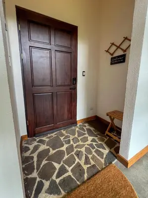 a room with a large wooden door and a rug at Casa Micelio in Monteverde Costa Rica