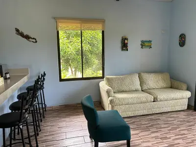 a living room with a couch and a table and chairs at Villas Carari 2 in Savegre
