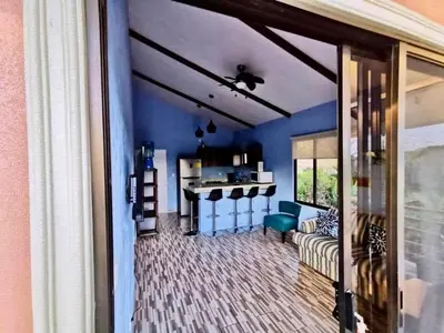 a living room with blue walls and a kitchen at Villas Carari 2 in Savegre