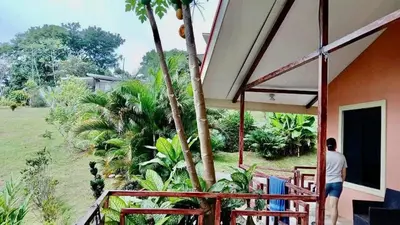 a man standing on the porch of a house at Villas Carari 2 in Savegre