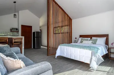 a bedroom with a large bed and a couch at Kalma Suite & Spa in Monteverde Costa Rica