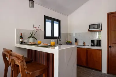 a kitchen with a counter with a table and chairs at Kalma Suite & Spa in Monteverde Costa Rica