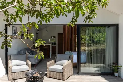 a patio with wicker chairs and a table at Kalma Suite & Spa in Monteverde Costa Rica