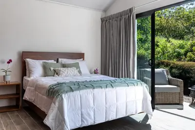 a bedroom with a bed and a sliding glass door at Kalma Suite & Spa in Monteverde Costa Rica