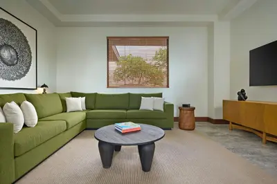 a living room with a green couch and a table at Nekajui Peninsula Papagayo, a Ritz-Carlton Reserve Residence in Papagayo, Guanacaste