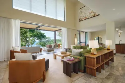 a living room with a green couch and chairs at Nekajui Peninsula Papagayo, a Ritz-Carlton Reserve Residence in Papagayo, Guanacaste