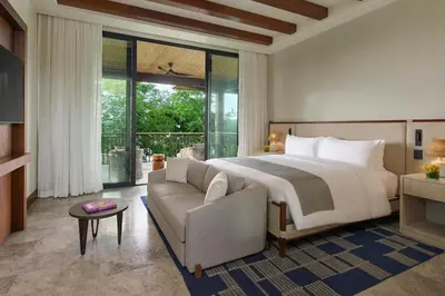a bedroom with a large bed and a couch at Nekajui Peninsula Papagayo, a Ritz-Carlton Reserve Residence in Papagayo, Guanacaste