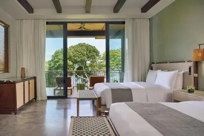 a hotel room with two beds and a balcony at Nekajui Peninsula Papagayo, a Ritz-Carlton Reserve Residence in Papagayo, Guanacaste