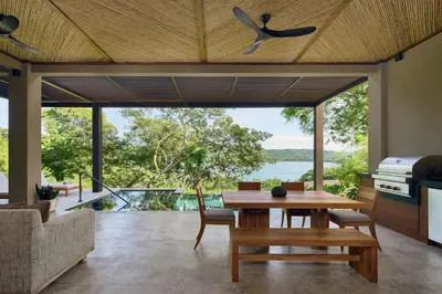 a dining room with a table and a view of the water at Nekajui Peninsula Papagayo, a Ritz-Carlton Reserve Residence in Papagayo, Guanacaste