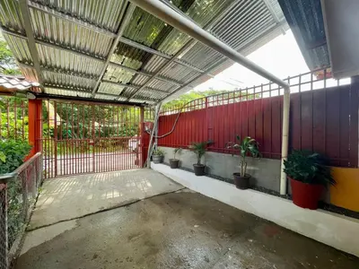 a patio with potted plants and a red fence at Apartamento el Almendro in Liberia