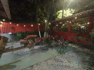 a garden with a table and a fence at night at Apartamento el Almendro in Liberia