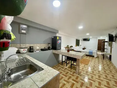 a kitchen with a sink and a living room at Apartamento el Almendro in Liberia