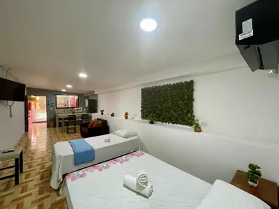 a room with two beds and a living room at Apartamento el Almendro in Liberia