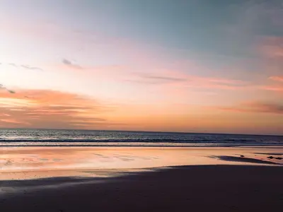 a sunset on a beach with the ocean at Blue Banana Villas in San José Pinilla