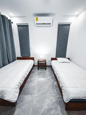 two beds in a room with a table between them at Blue Banana Villas in San José Pinilla