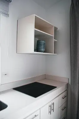 a kitchen with white cabinets and a bowl on a shelf at Blue Banana Villas in San José Pinilla