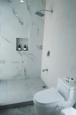 a white bathroom with a toilet and a shower at Blue Banana Villas in San José Pinilla