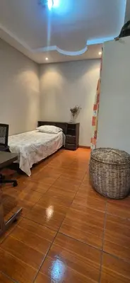 a bedroom with a bed and a wooden floor at Casa Sarita y Manuel in Curridabat