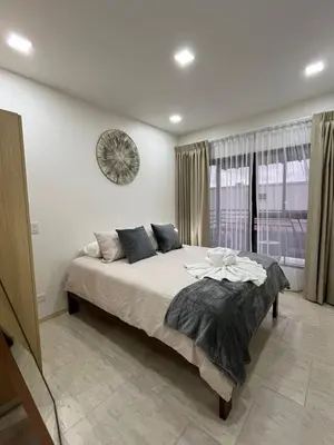a bedroom with a large bed with a clock on the wall at Los Ángeles in Fortuna