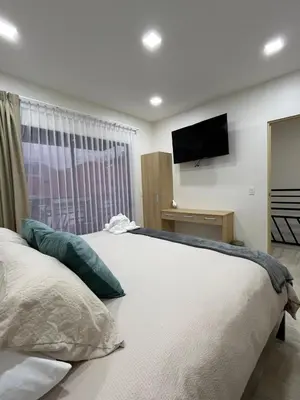 a bedroom with a large bed with a television on the wall at Los Ángeles in Fortuna