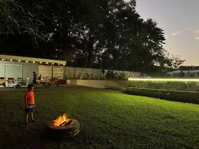 a young boy standing next to a fire in a yard at Seven Paradise - Your personal rainforest in Fortuna