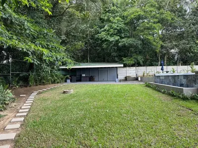 a yard with a building in the background at Seven Paradise - Your personal rainforest in Fortuna