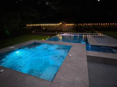 a swimming pool at night with lights around it at Seven Paradise - Your personal rainforest in Fortuna