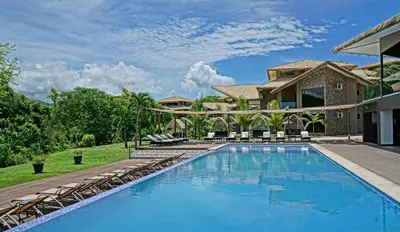 a swimming pool in front of a house at Nammbú Beach Front Bungalows in Sámara