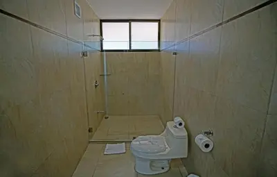 a bathroom with a toilet and a shower at Nammbú Beach Front Bungalows in Sámara