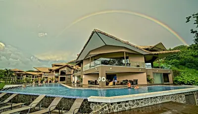 a house with a swimming pool in front of it at Nammbú Beach Front Bungalows in Sámara