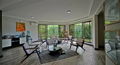 a living room with chairs and a table at Nammbú Beach Front Bungalows in Sámara