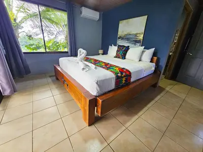 a bedroom with a large bed with a large window at Famillies Getaway - 3Bed & 2Bath in Arenal Volcano in Fortuna