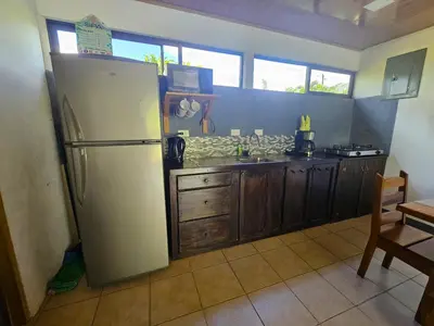 a kitchen with a white refrigerator and wooden cabinets at Famillies Getaway - 3Bed & 2Bath in Arenal Volcano in Fortuna
