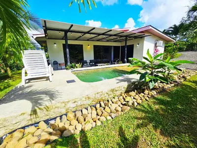 a villa with a pool and a chair in a yard at Famillies Getaway - 3Bed & 2Bath in Arenal Volcano in Fortuna