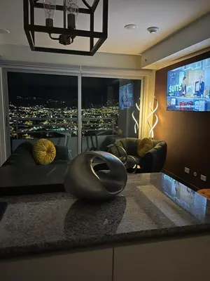 a living room with a view of a city at night at Exclusive apartment in downtown Costa Rica in San José
