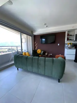 a green couch in a living room with a large window at Exclusive apartment in downtown Costa Rica in San José