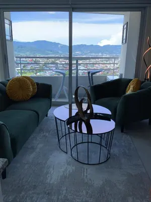 a living room with couches and a table with a view at Exclusive apartment in downtown Costa Rica in San José
