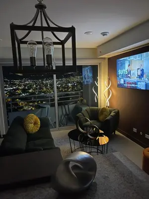 a living room with a tv and a couch and chairs at Exclusive apartment in downtown Costa Rica in San José