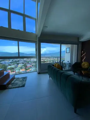 a living room with a couch and large windows at Exclusive apartment in downtown Costa Rica in San José